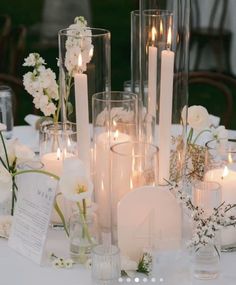 there are many candles and flowers on the table