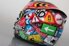 a helmet covered in lots of different types of signs on it's face and sides