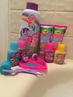 a bath tub with toys on it next to a bottle and toothbrush in the sink