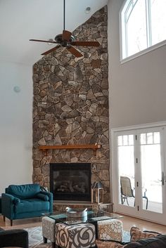 a living room filled with furniture and a stone fireplace