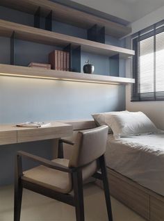 a bed sitting under a window next to a desk