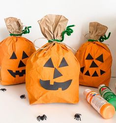 three halloween bags with jack - o'- lantern faces on them and some glue sprinkles