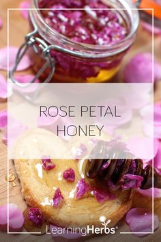 rose petal honey in a glass jar on a wooden table with petals around it