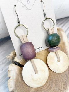 the earrings are made out of wood and have two different colored beads on each ear