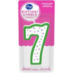 a birthday candle with the number seven on it's front in pink and green