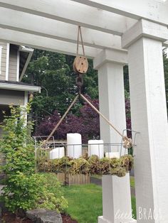 an outdoor area with white pillars and hanging planters