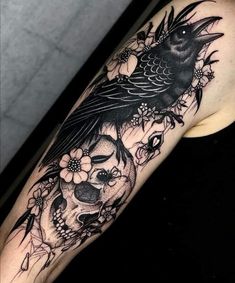 a woman's arm with a bird and skull tattoo on it