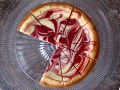 a cake with red and white swirled icing on it's crust is cut into pieces