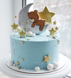 a blue cake decorated with stars and a teddy bear