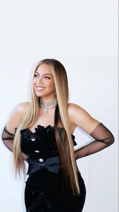 a woman with long blonde hair wearing a black dress