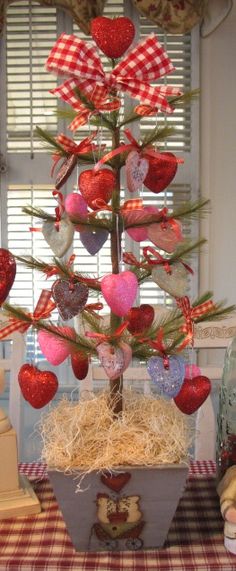 a small christmas tree with hearts hanging from it