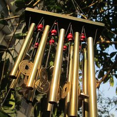 a wind chime hanging from the side of a tree with bells attached to it