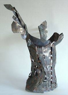 a metal sculpture that has been made to look like a woman's torso and arms