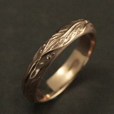 a wedding ring with an intricate design on the outside and inside, sitting on a black surface