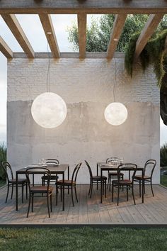 an outdoor dining area with tables and chairs on the wooden floor, surrounded by stone walls