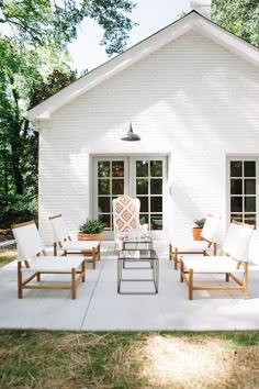 a white house with chairs and tables outside