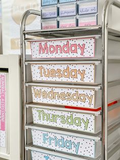 a metal cart with several days of the week signs on it