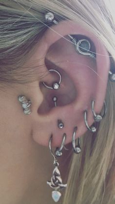 a close up of a person's ear with multiple piercings on the side