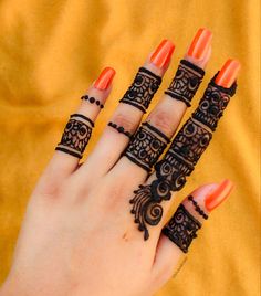 a woman's hand with henna tattoos on her fingers and two finger rings