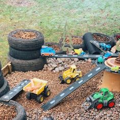 there is a toy train set on the ground next to some tires and other toys