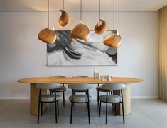 a dining room table with four chairs and a painting on the wall in the background