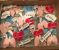 a box filled with decorated cookies in the shape of medical symbols