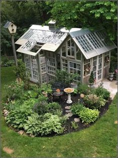 a small house surrounded by lots of plants and trees