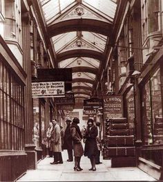 an old photo of people walking down the street