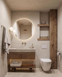 a bathroom with a toilet, sink and mirror