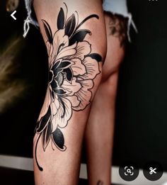 a woman's leg with black and white flowers on it