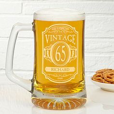 a glass mug with the number 66 on it next to a bowl of cookies and a white brick wall