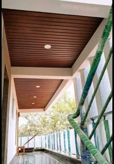 an indoor swimming pool with wooden ceiling and tile flooring on the outside side of it