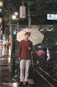 a man walking down the street holding an umbrella