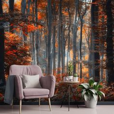 a chair and table in front of a wall mural with an autumn forest scene on it