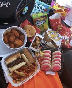 a bunch of food that is sitting on a table in the back seat of a car