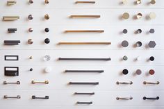 a bunch of different types of handles and knobs on a white wall with gold accents