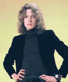 a woman is posing with her hands on her hips and looking at the camera while wearing a black jacket