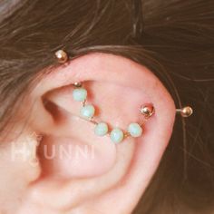 a close up of a person wearing ear piercings with beads on it's sides