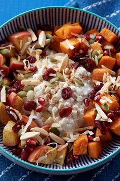 a bowl filled with fruit and nuts on top of a blue table cloth