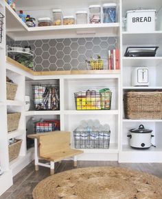 an organized pantry with white shelves and baskets