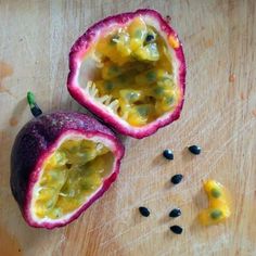 an open passion fruit on a cutting board with seeds scattered around it and one cut in half