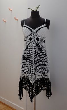 This crocheted dress is the perfect thing to throw on over your swimsuit when you're beach bumming around. The bust has adequate coverage, so you could even take of your wet swimsuit top and wear this bra-less, while your swimsuit bottom air dries through the large crochet holes.  The white yarn is cotton and the black is polyester.  Bust: 32/34 A Under bust: 32"  Shoulder to hem: 42" Fitted Beach Dress With Crochet Trim, Fitted Crochet Dress With Crochet Trim For Summer, Fitted Summer Crochet Dress, Fitted Summer Crochet Dress With Crochet Trim, Fitted Sleeveless Crochet Dress For Beach, Fitted Crochet Lace Dress For Vacation, Fitted Bohemian Cover-up For Summer, Fitted Beach Dress For Festivals, Fitted Beach Dress For Beach Season Festivals