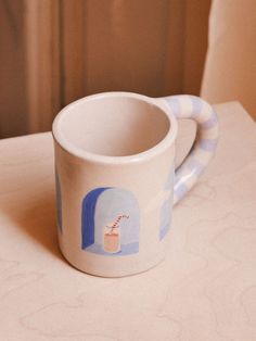 a coffee cup with a handle sitting on top of a table