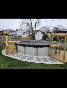 an above ground pool with steps leading up to it and a hot tub in the middle