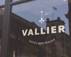 the reflection of an old building is seen in the glass door of a storefront