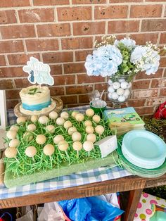 a table topped with lots of cake and desserts next to a brick wall in the background