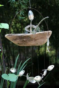 a wind chime hanging from the side of a tree with white birds on it