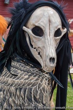 a person in a costume with an animal's head on their shoulders and the face painted white