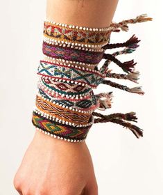 a woman's arm with several bracelets on it