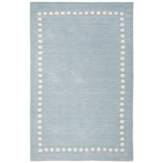 a light blue rug with white dots on the border and a square shape in the middle